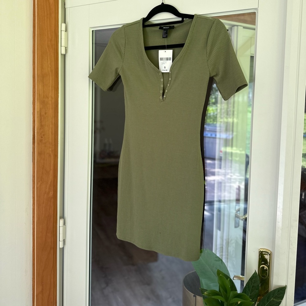 Olive green, ribbed cotton mini dress with a “v” snap closure detail.